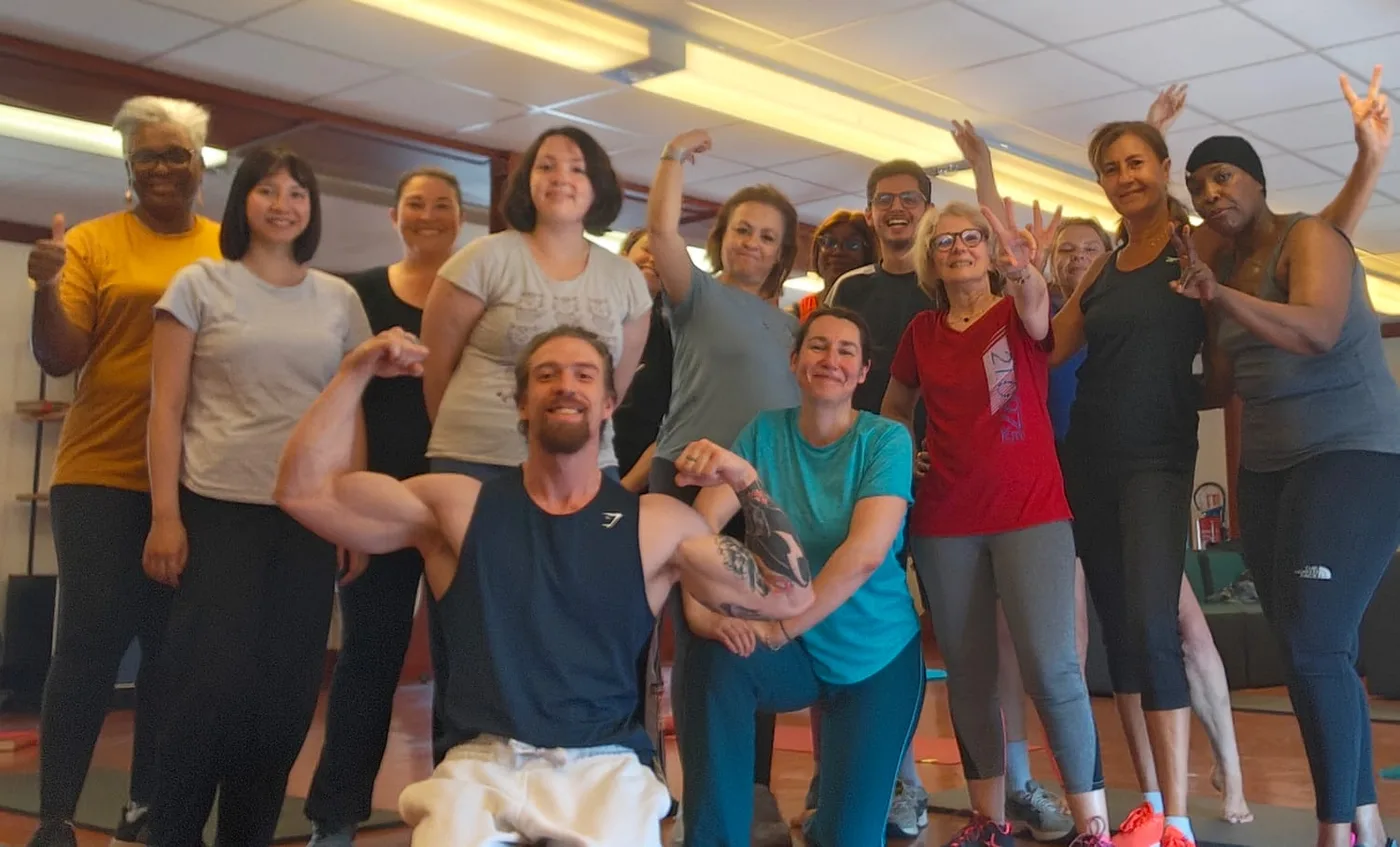 Équipe de salariés réunie et souriante à la fin d'une séance de sport collective en entreprise